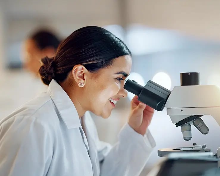 Woman looking into a microscope