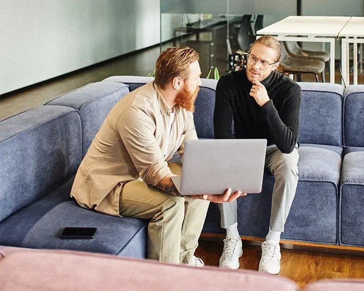 Two colleagues sitting on a couch having a meeting