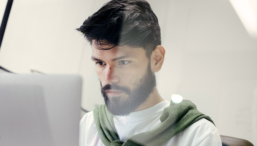 Photo of a man working on a laptop