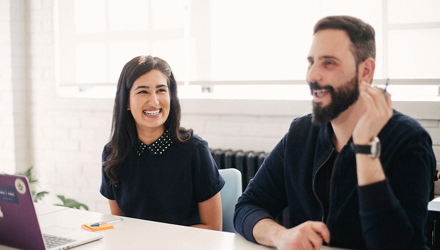 A photo of two colleagues at a conference table