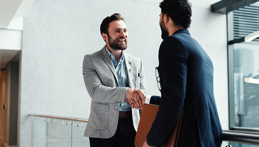 Two financial services professionals shaking hands